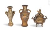 trois vases posés l'un à côté de l'autre sur une surface blanche