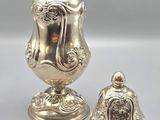 two silver vases sitting on top of a table next to each other