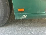 a close up of a green bus parked on the side of the road