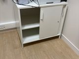 une armoire blanche sur laquelle sont posés une imprimante et un grille-pain