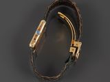 an image of a gold and leather bracelet with a blue stone