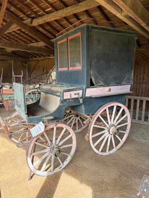 une calèche qui se trouve dans une grange