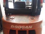 an orange forklift truck parked in a parking lot
