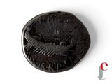 an old coin with a boat on it sitting on top of a white surface