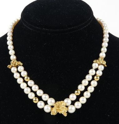 un collier composé de perles et de perles en or sur un mannequin noir