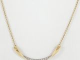 a gold plated necklace with a curved bar with diamonds on it