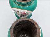 two green vases sitting next to each other on a white surface