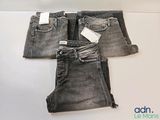 three pairs of grey jeans sitting on top of a white table