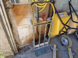 un petit chariot muni d'un tuyau et d'une roue, posé contre un mur