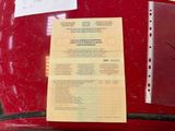 a document on the back of a red car
