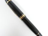 an image of a black pen with gold trim sitting on top of a white surface