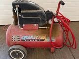 an image of a small air compressor in a garage