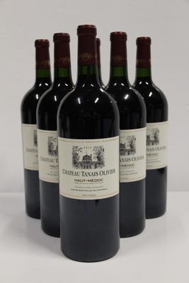 four bottles of red wine are lined up on a white surface