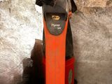un aspirateur rouge et noir posé par terre