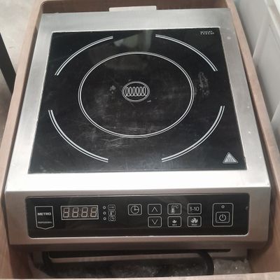 une plaque de cuisson noire et argentée dans une boîte en bois
