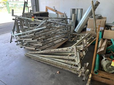 un tas d'objets métalliques dans un garage, à côté d'un tas d'autres objets