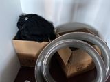a box and a hose in the corner of a room