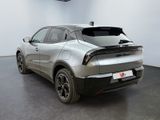 the rear end of a silver car in a white room