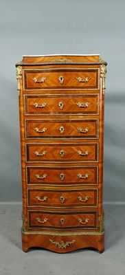 une commode ancienne avec des bordures dorées sur les tiroirs