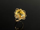 une bague en or sertie d'une citrine de taille ovale, entourée de motifs en filigrane