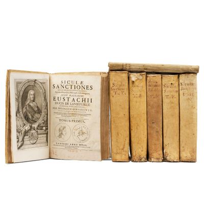 several old books are stacked on top of each other on a white surface