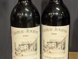 two bottles of wine sitting on a table next to each other