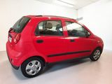 a small red car parked in a white room