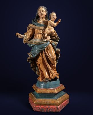 une statue de femme tenant un enfant sur un piédestal