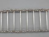 a close up of a row of silver pins on a gray surface