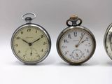 three different types of pocket watches are displayed on a white surface