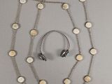 collier et écouteurs suspendus à une chaîne en argent ornée de cercles blancs