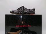 une paire de chaussures à imprimé zèbre noir et blanc avec des semelles rouges