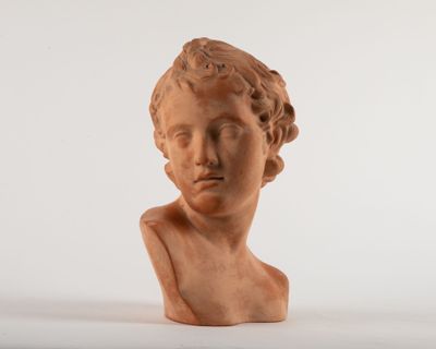 statue of a young boy ' s head on a white surface