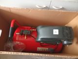 a red air compressor in a cardboard box