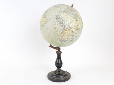 un vieux globe terrestre posé sur un socle, sur fond blanc
