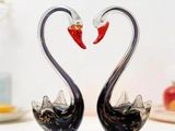 two glass swans making a heart shape with their necks