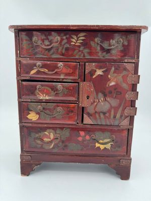 une image représentant une commode en bois ornée de fleurs et d'oiseaux