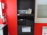 une photo d'un petit bureau avec un mur rouge