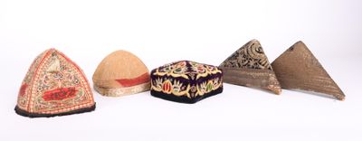 Plusieurs types de chapeaux sont alignés sur une surface blanche