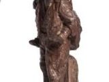 a statue of a man standing next to a bottle of wine