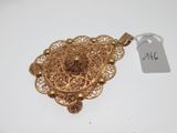 an image of a gold pendant with a tag attached to it