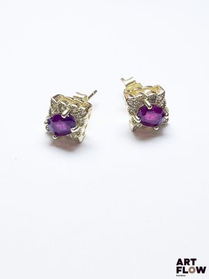 une paire de boucles d'oreilles en pierre violette sur fond blanc