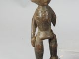 a small wooden statue of a boy on a black base