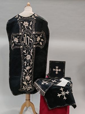 une croix noire et blanche sur un tissu noir et rouge