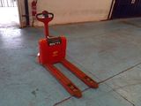 un chariot élévateur rouge posé à même le sol dans un garage