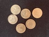 four different types of coins on a black surface