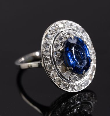 an image of a sapphire and diamond ring on a black surface