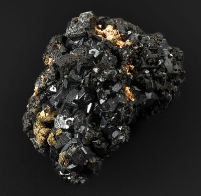 un morceau de minéral noir et doré posé sur une surface noire