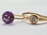 a close up of two rings with purple stones on them