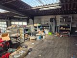 une pièce où il y a beaucoup de boîtes et de cartons sur le sol